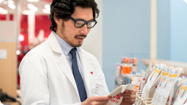 A CVS Pharmacy technician checking a prescription bag.